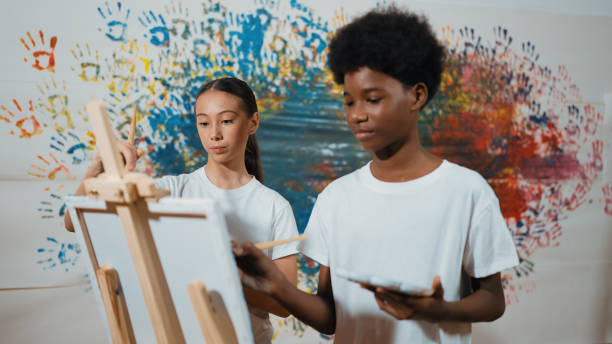 istock Diverse happy children paint canvas together with stained wall. Edification. 2157931319