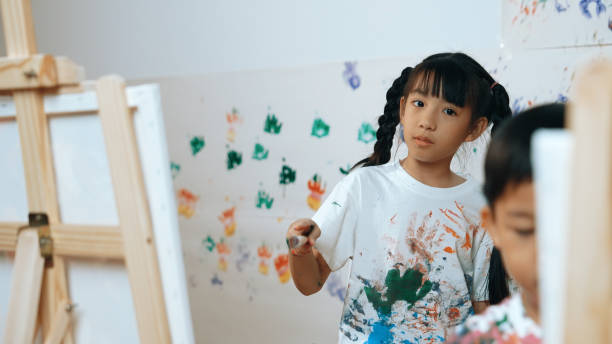 istock Young student painted or draw canvas at stained wall in art lesson. Erudition. 2157931755