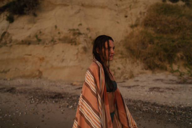 istock Young woman at the sandy beach at sunset 2157931903