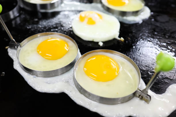 Fried egg in stainless steel mood ring on hot pan