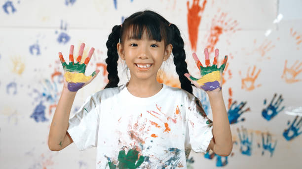 istock Asian student put hands up together show colorful stained hands. Erudition. 2157933163