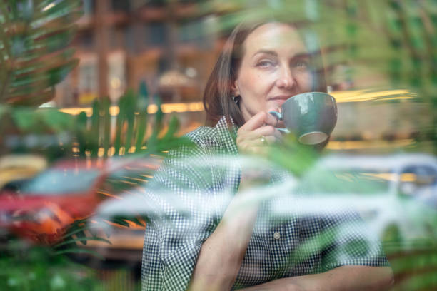 istock Thoughtful business woman sits at cafe, drinking coffee and looking through window 2157933562