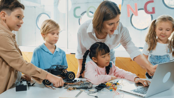 istock Smart teacher and diverse student looking at laptop at classroom. Erudition. 2157935917
