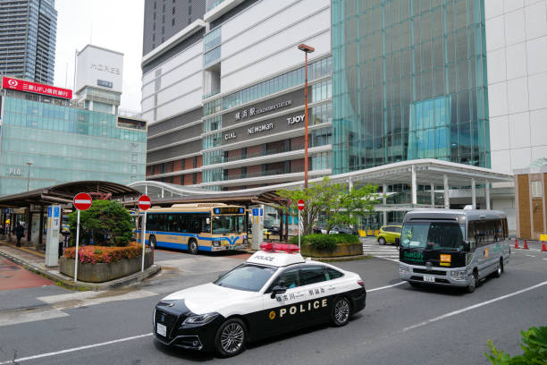 Japan Yokohama 28 May 2024: A police car leaving Yokohama Station and some Public Bus on the Background.