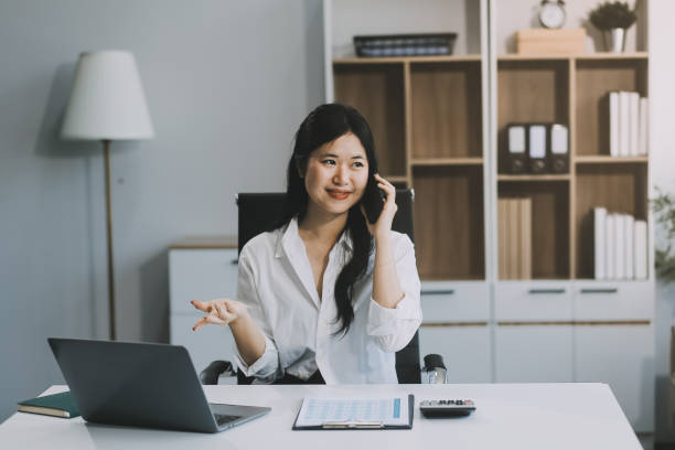 istock Attractive asian woman using a laptop PC and a smart phone. 2157936349