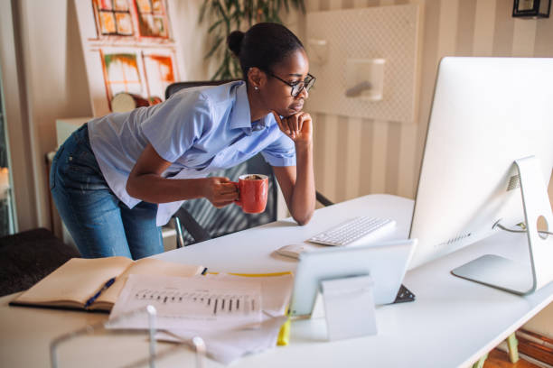 istock Black woman drinking coffee while on an online meeting 2157936662