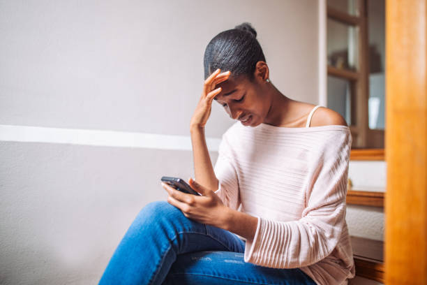 istock Black girl holding a smart phone and crying 2157936706