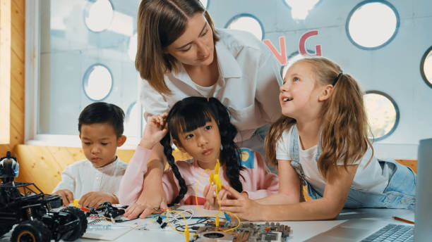 istock Teacher looking at children while diverse student looking at screen. Erudition. 2157937482