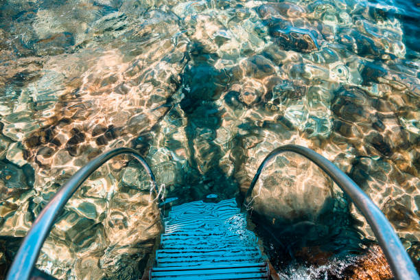 Ladder leading into the sea water. Isola Bella beach, Sicily, Italy