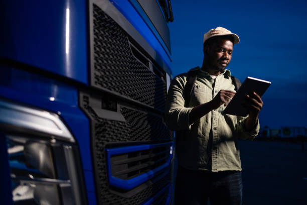 istock Experienced truck driver preparing GPS navigation equipment before night drive. 2157938938