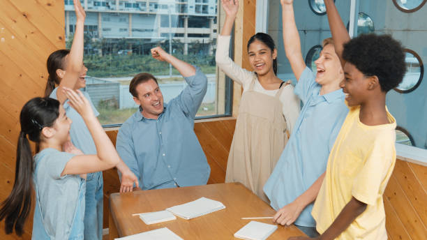 istock Teacher and diverse children putting hand together. Love and unity. Edification. 2157940402