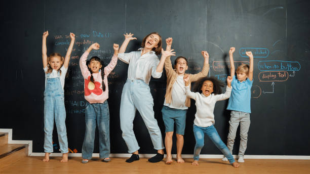istock Multicultural student and teacher smiling and standing at blackboard. Erudition. 2157940613