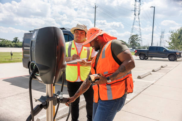 istock Inspecting EV charging station. Engineers in high visibility vests examine electric vehicle charger outdoors. 2157942921