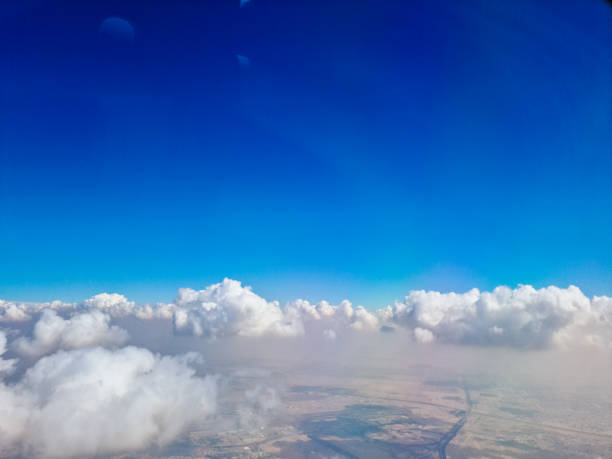 View from the airplane window mid air, above the clouds.