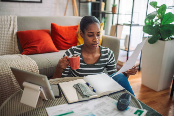 istock Black woman paying the bills online and drinking coffee 2157946449