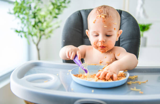 istock Little baby eating her dinner and making a mess 2157948153