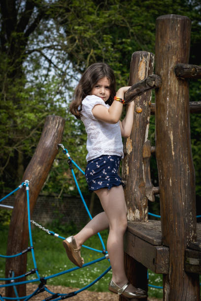 istock A girl climbs a rope swing on a tree in the park. 2157948349