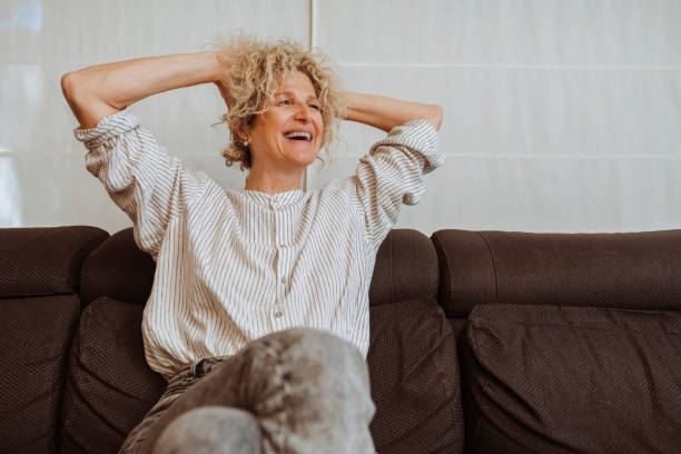 istock Happy middle aged woman relaxing on sofa at home 2157948643