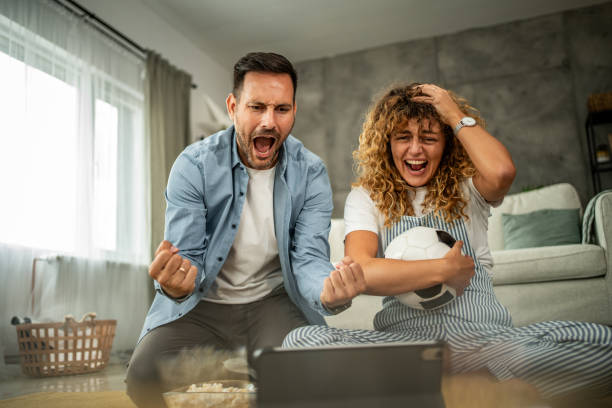 istock Couple watching soccer match together on digital tablet at home 2157951202