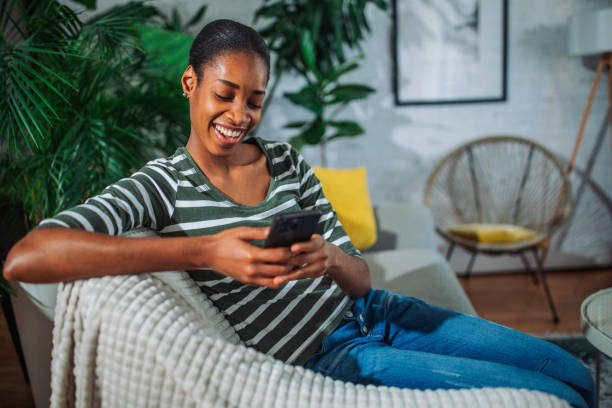 istock Black young woman using a smart phone and smiling 2157951259