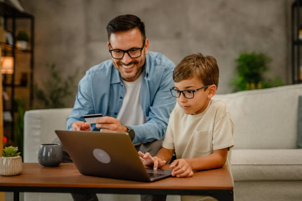 istock Father and son at home looking on laptop and shopping online, using technology lifestyle concept 2157951344