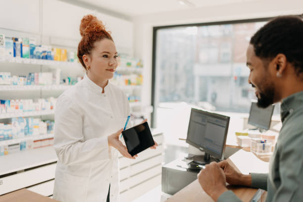 istock Pharmacist offering tablet to customer for signature 2157952390