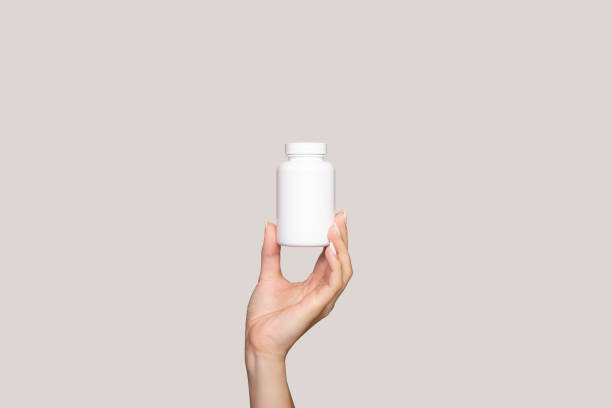 A young woman's hand holds a white plastic bottle