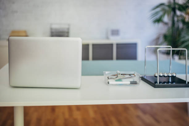 Office desk with a grey laptop and office supplies