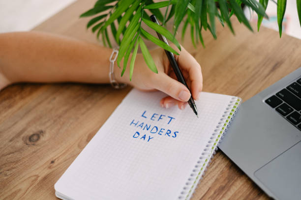 istock Woman writes by her left hand in a notebook the text left handers day 2157955362