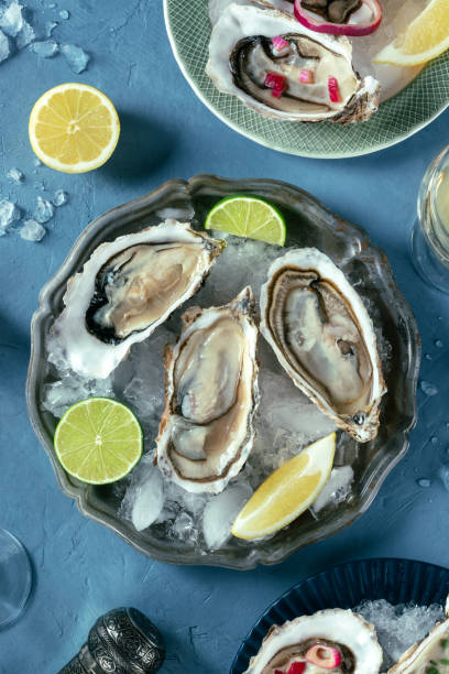 istock Oysters on a dish with ice, with lemon and lime, overhead flat lay shot 2157956400