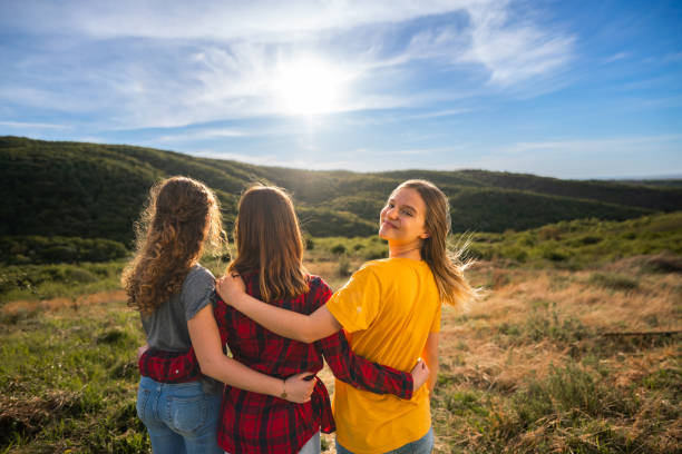 istock Happy girls stand hugging on the hill during sunset 2157959809