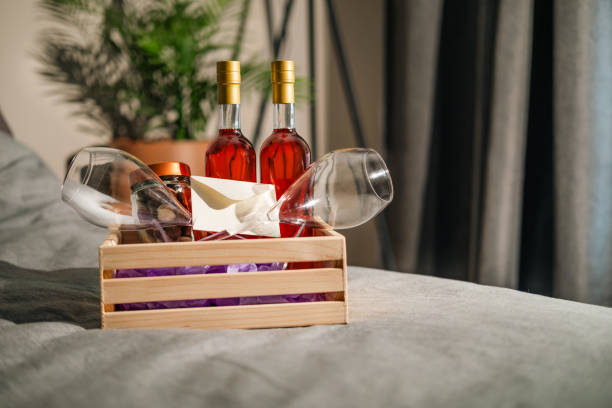 istock Wine and chocolate in a welcome basket for guests on the bed. 2157961859