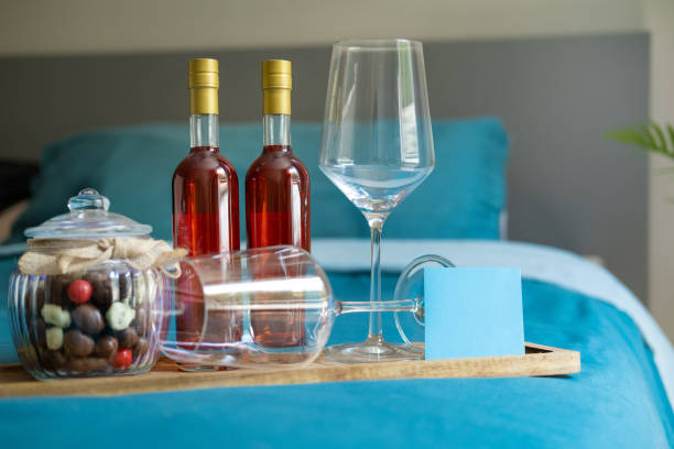 A glass bottle, a glass shaker, and two glasses are on a tray on a table in the living room