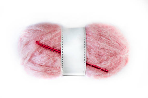 Ball of pink mohair wool against a white background
