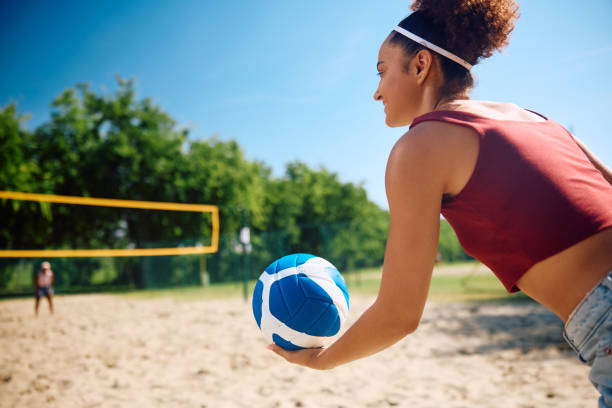 istock Happy woman serving the ball while playing beach volleyball. 2157966090