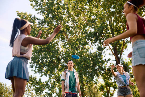 istock Happy friends having fun while playing with frisbee in the park. 2157966320