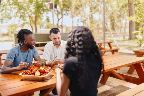 istock Multiracial people eating seafood outdoors 2157968188