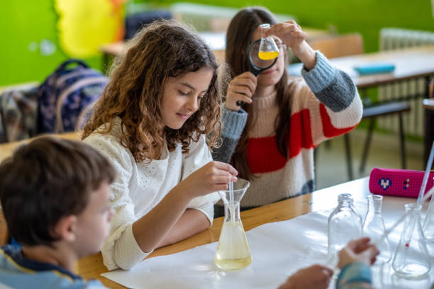 teenagers at school learning about chemistry,sitting on benches together teenagers at school learning about chemistry, mixing chemicals, sitting on benches together, in the classroom, laughing, studying, researching, reading, microscope cute teen pic stock pictures, royalty-free photos & images