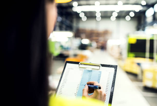 istock Manager woman in reflective safety clothes, holding clipboard with documents, controlling goods in warehouse. 2157971398