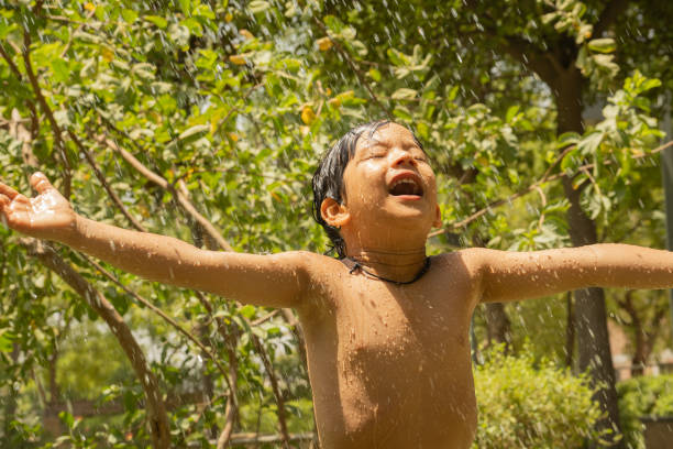 Little boy playing with water in the yard