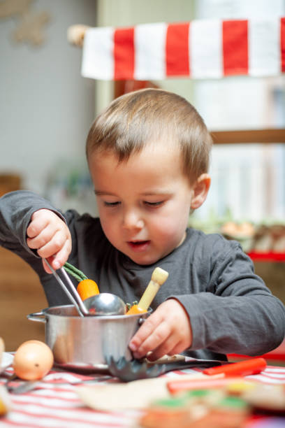 istock Child stirs with spoon wooden cooking set food. Children's cognitive development. 2157975943