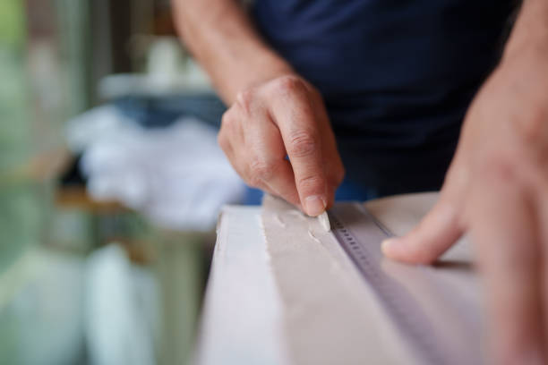 istock Tailor is marking the fabric with soap to cut out the pattern. 2157976888