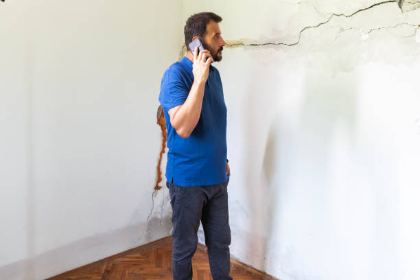 istock Mature man looking at a wall damaged after the earthquake 2157978797