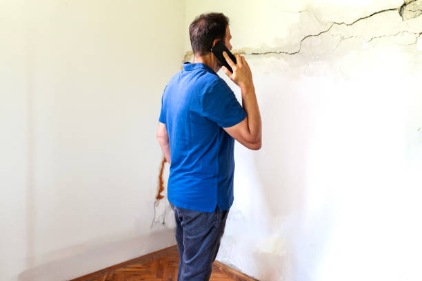 istock Mature man looking at a wall damaged after the earthquake 2157978803