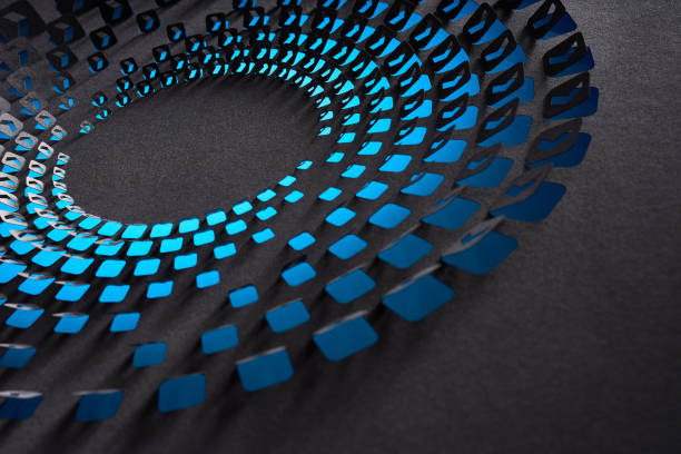 Native image size: 7952 x 5304. This captivating still life photograph showcases a dynamic cut paper artwork with a circular pattern of blue shapes arranged on a dark gray background. The precise cutouts and the interplay of light and shadow create a sense of depth and movement, emphasizing the meticulous craftsmanship and artistic vision behind the design. This image is perfect for illustrating creative paper art and geometric design concepts.