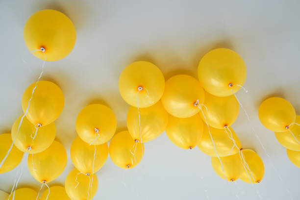 Gas-filled yellow balloons rose to the ceiling.