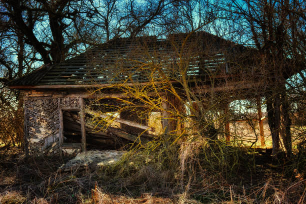 Single Engine Airplane Crashed into a Weathered Old Barn Collapsing Under a Blue Sky in the Old West