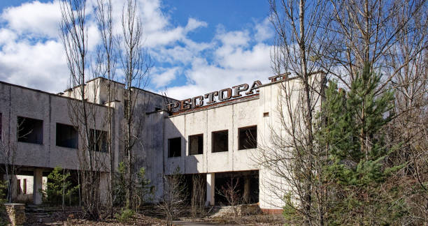 istock A dilapidated building with the word on top, surrounded by bare trees and overgrown vegetation. An abandoned restaurant in Pripyat. Ruins of a building in a city contaminated with radiation. 2157988260