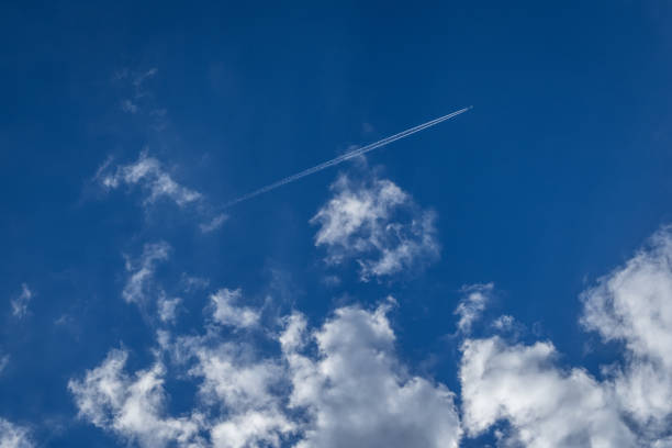 Blue sky with white clouds and airplane on a summer sunny day