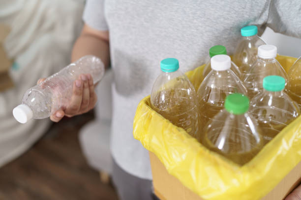 istock Home recycle eco green zero concept Man throwing empty plastic bottle in recycling bin with yellow garbage bags at home 2157991812